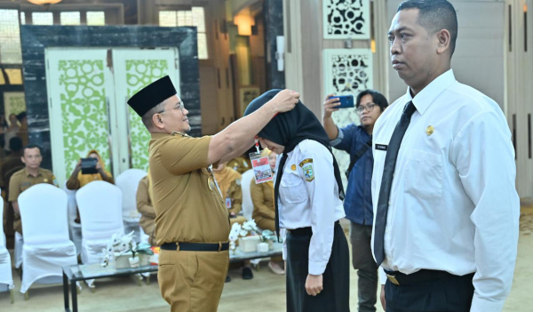 Wali Kota Jambi, Maulana, memasang tanda peserta orientasi PPPK | dki