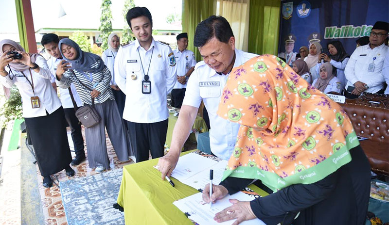 Penandatanganan naskah kerja sama oleh Ketua Gerami Kota Jambi, Hj Masturo, dan Kepala Dinas Pendidikan Kota Jambi, Mulyadi | dki-kj