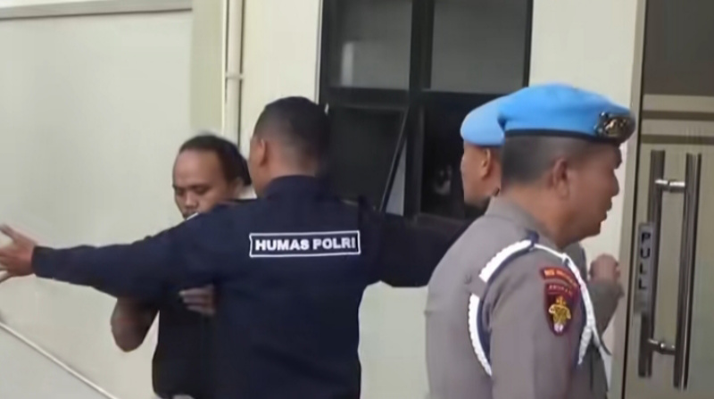Seorang personel Bidang Humas Polda Jambi menghadang seorang jurnalis yang meliput di Polda Jambi | foto : video amatir
