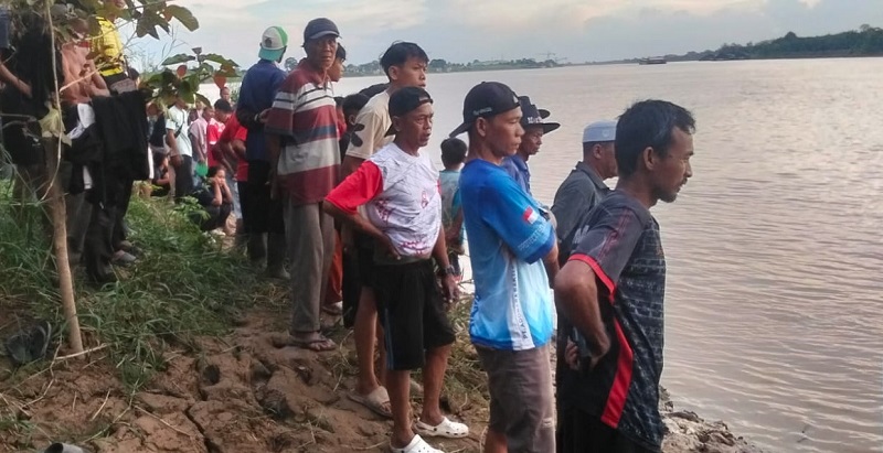 Warga menyaksikan Tim SAR Gabungan melakukan operasi pencarian seorang bocah yang hanyut di Sungai Batanghari | sar
